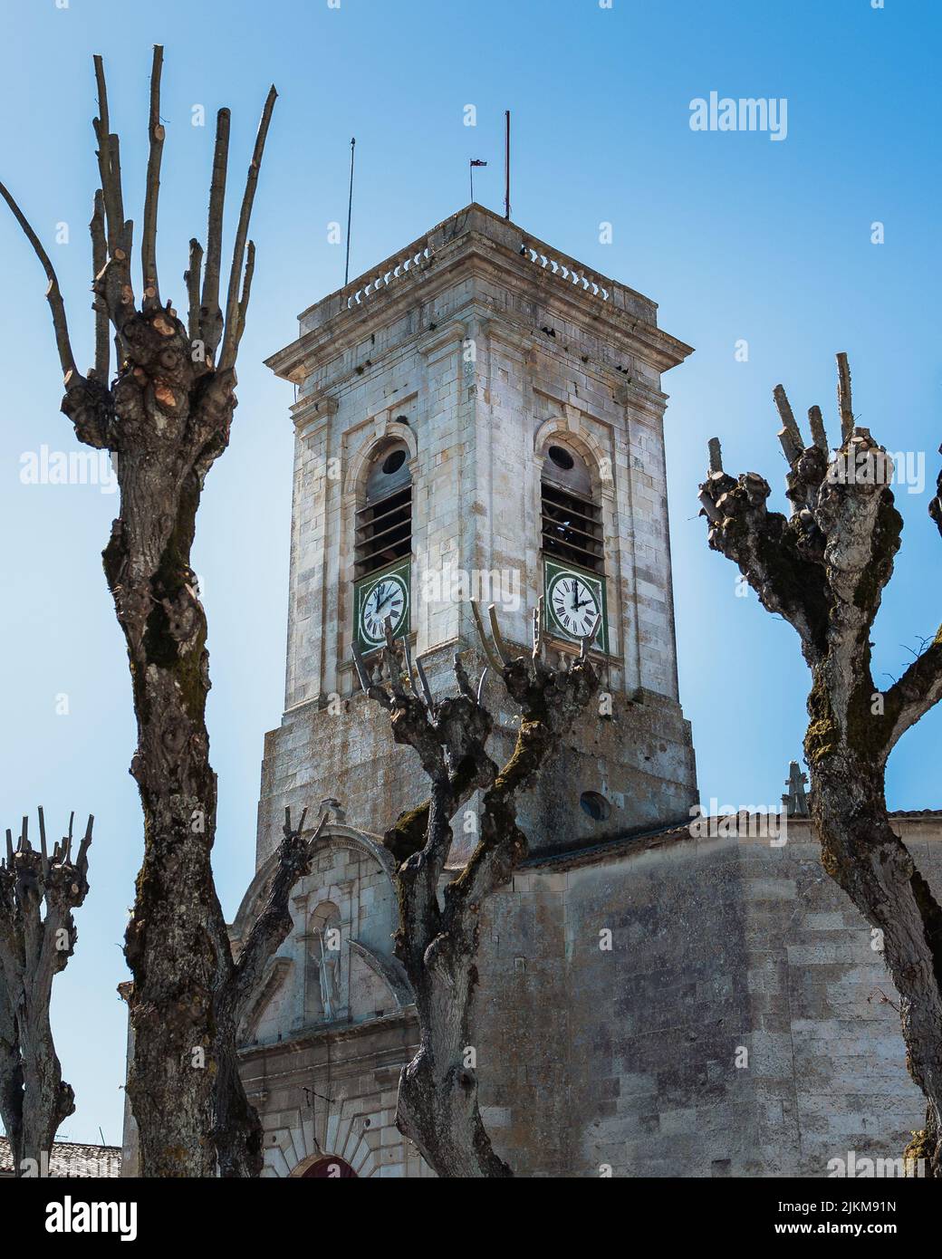 A vertical shot of a church with clocks on the walls on a blue sky background Stock Photo