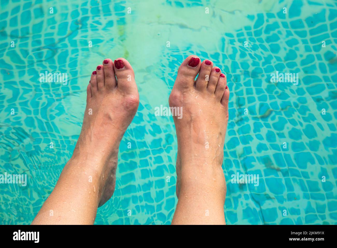 water temperatur in a swimming pool with feets in summer Stock Photo