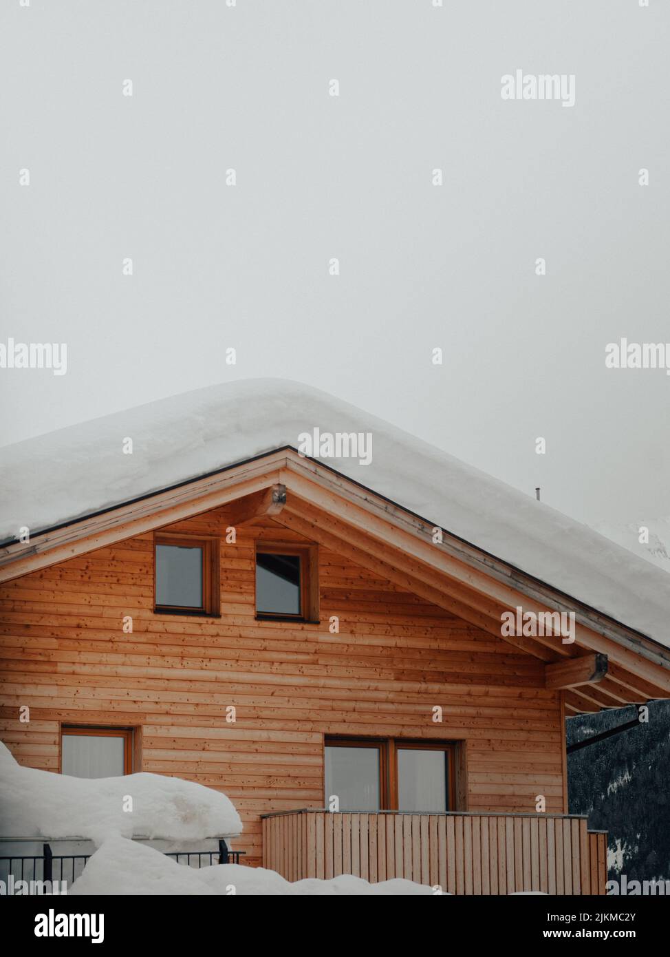 A vertical shot of the roof of a wooden house covered in snow Stock ...