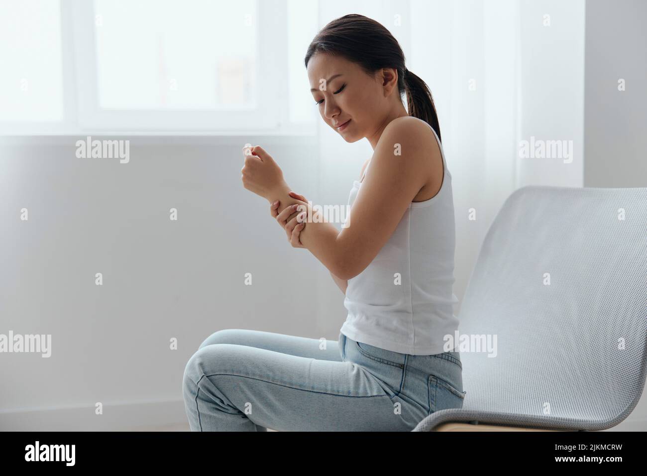 https://c8.alamy.com/comp/2JKMCRW/tormented-suffering-from-dislocation-tanned-beautiful-young-asian-woman-hurting-holding-painful-wrist-at-home-interior-living-room-injuries-poor-2JKMCRW.jpg