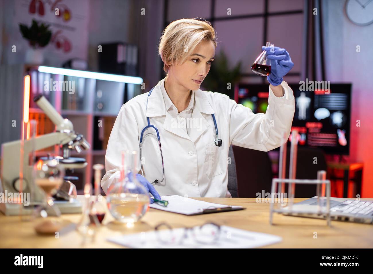 Female scientist working in modern lab. Doctor making microbiology research. Laboratory tools: microscope, test tubes, equipment. Coronavirus covid-19, bacteriology, virology, dna and health care. Stock Photo