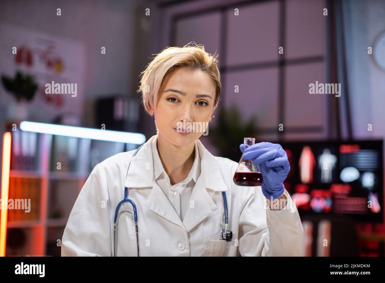 Female scientist working in modern lab. Doctor making microbiology research. Laboratory tools: microscope, test tubes, equipment. Coronavirus covid-19, bacteriology, virology, dna and health care. Stock Photo
