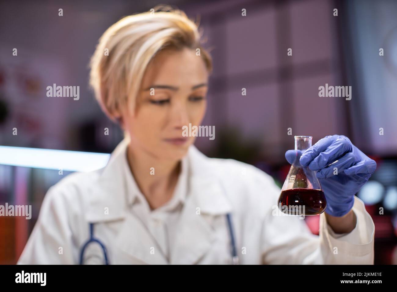 Modern medical research laboratory female scientist working with flask