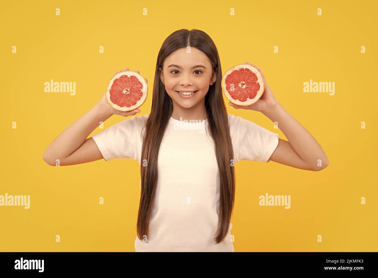 glad teen girl with grapefruit. vitamin and dieting. child eating healthy food. Stock Photo