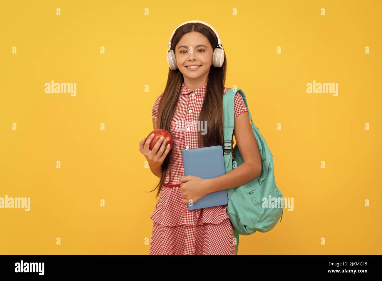 happy school kid in headphones carry backpack and workbook with apple