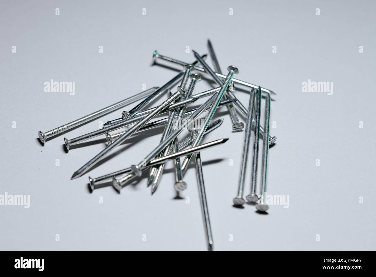 A closeup shot of construction screws isolated on gray background Stock Photo