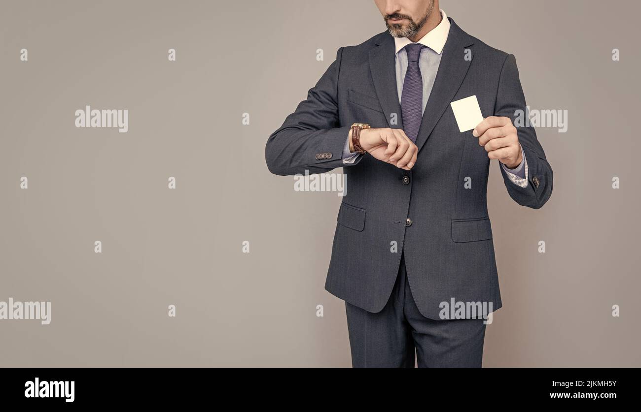 confident businessman man in suit showing debit card cheking time for copy space, fast payment Stock Photo