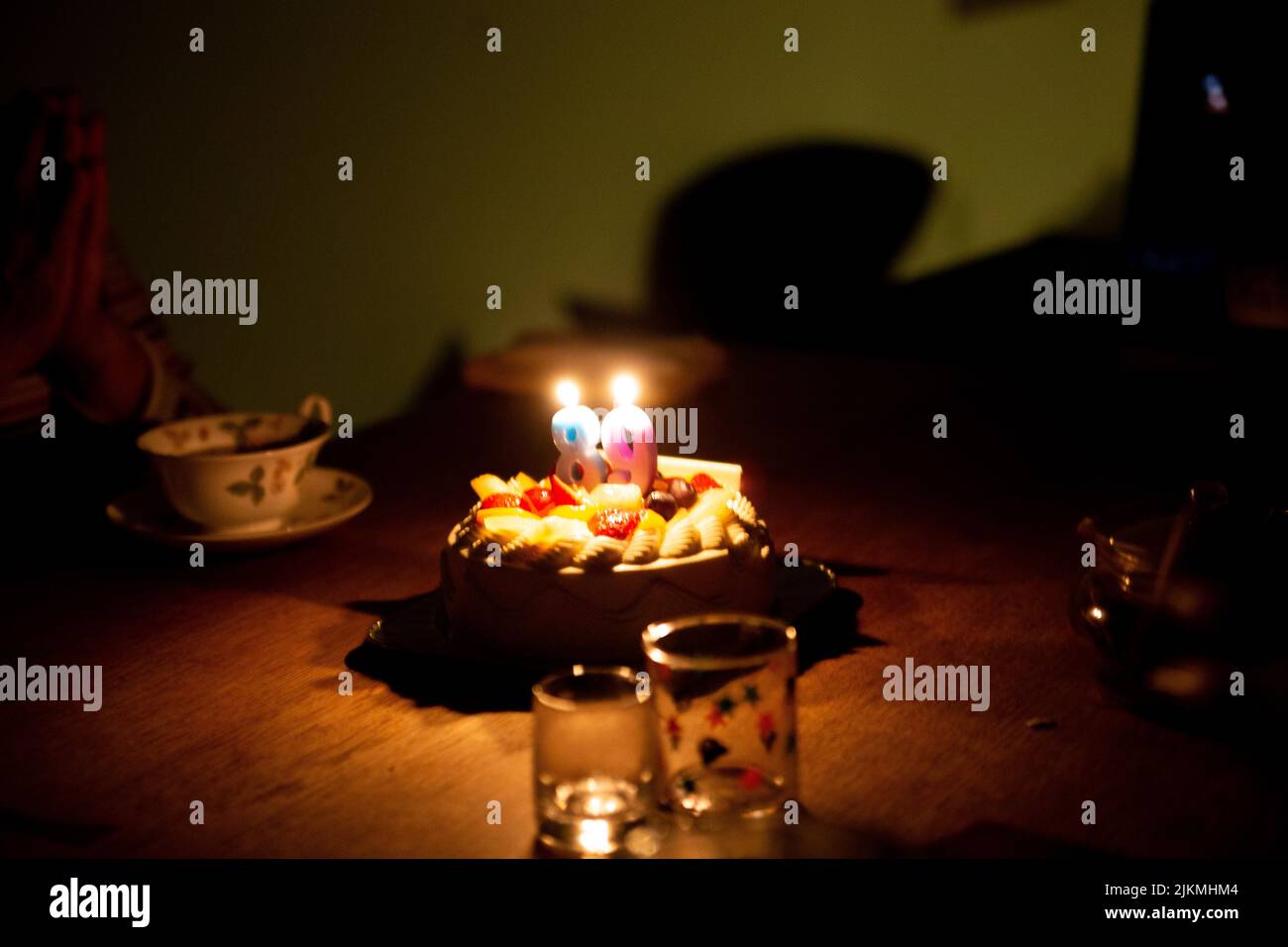 Candles in the shape of 8 and 9 are lit on the 89th Birthday Cake Stock