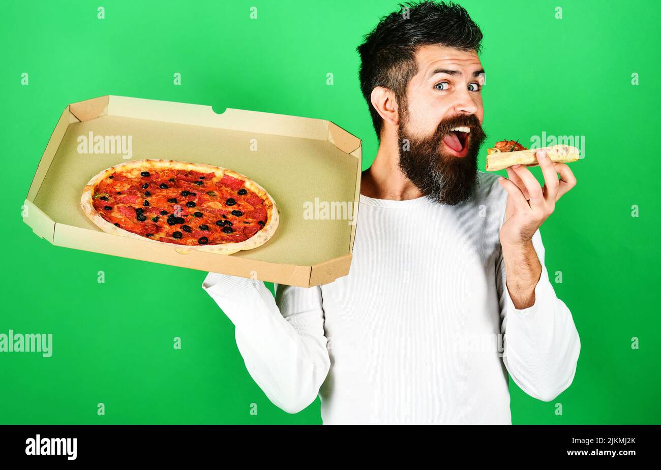 Hungry man eating slice tasty pizza. Food delivery home. Man with beard enjoying delicious pizza Stock Photo