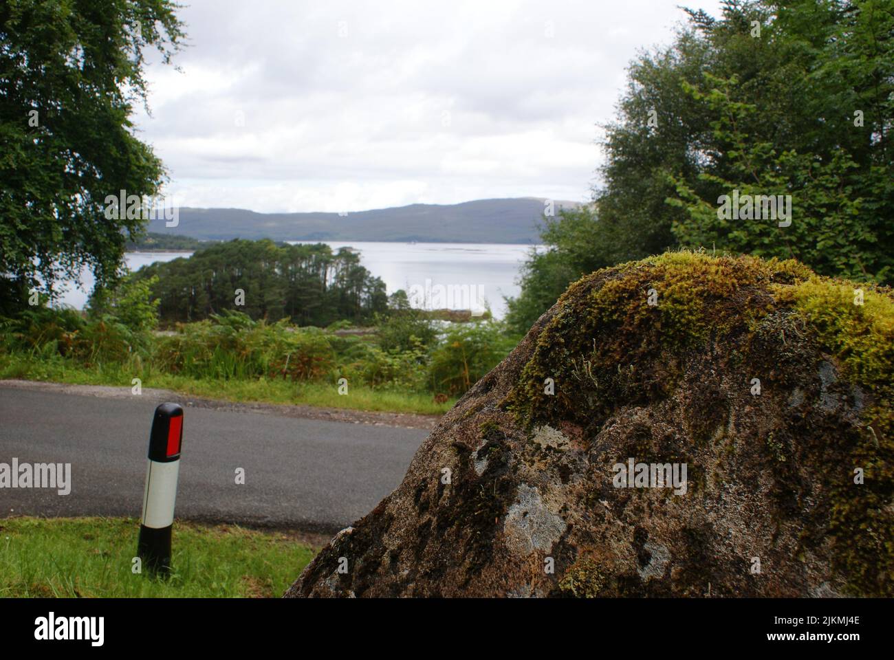 A big rock boulder with moss near the road in Scotland Stock Photo
