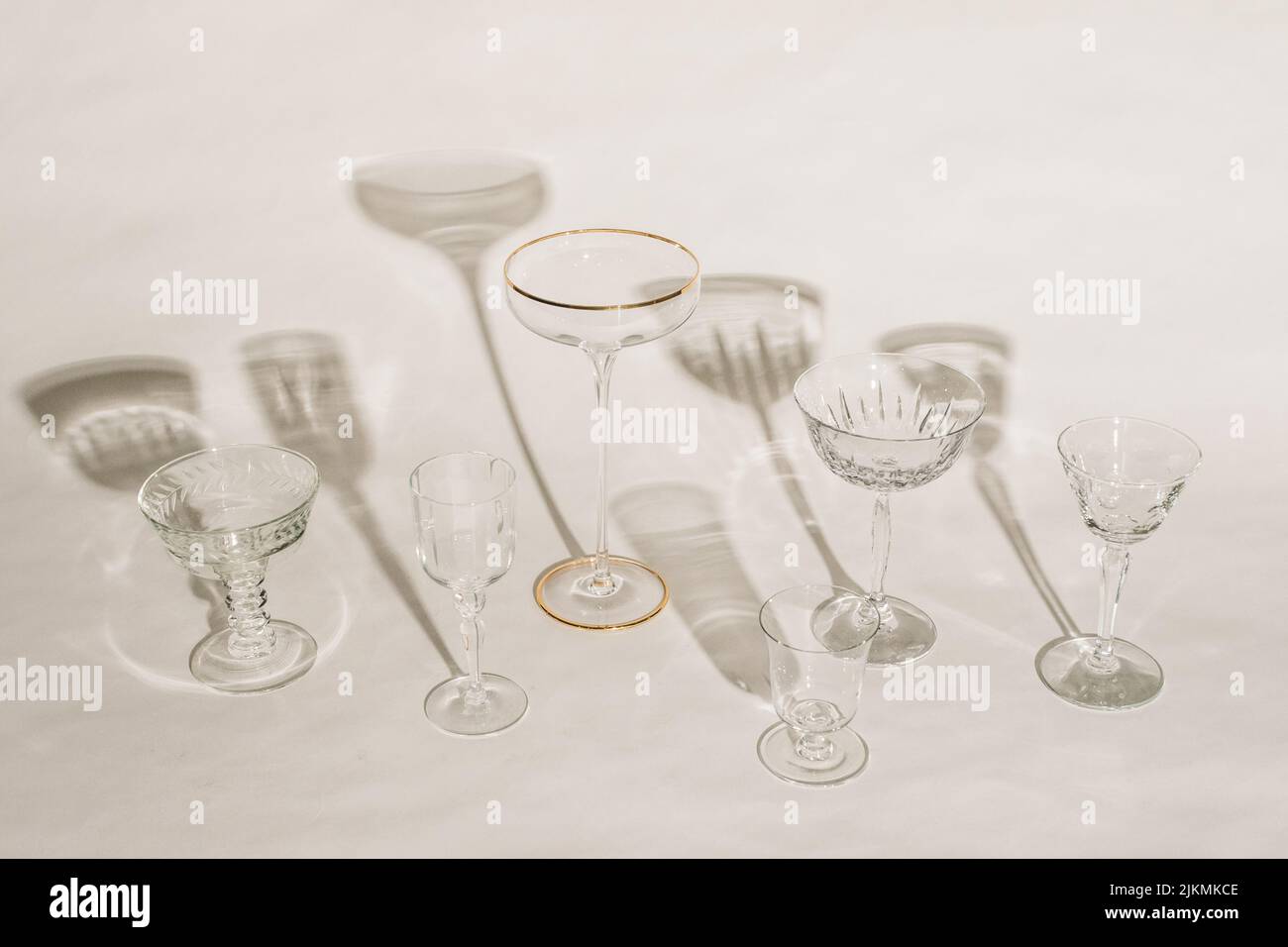 collection of assorted empty cocktail glasses against white background with shadows Stock Photo