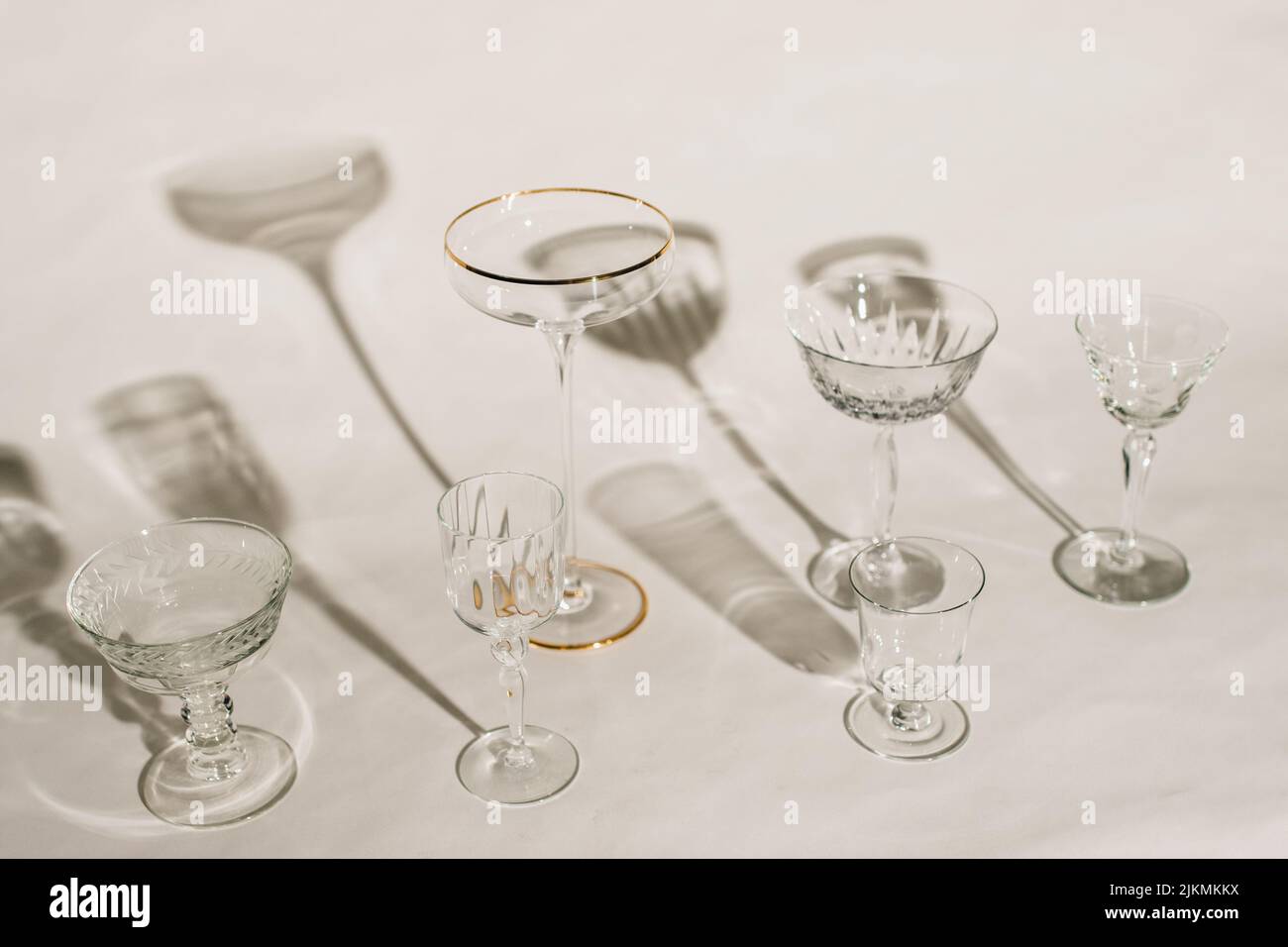 collection of assorted empty cocktail glasses against white background with shadows Stock Photo