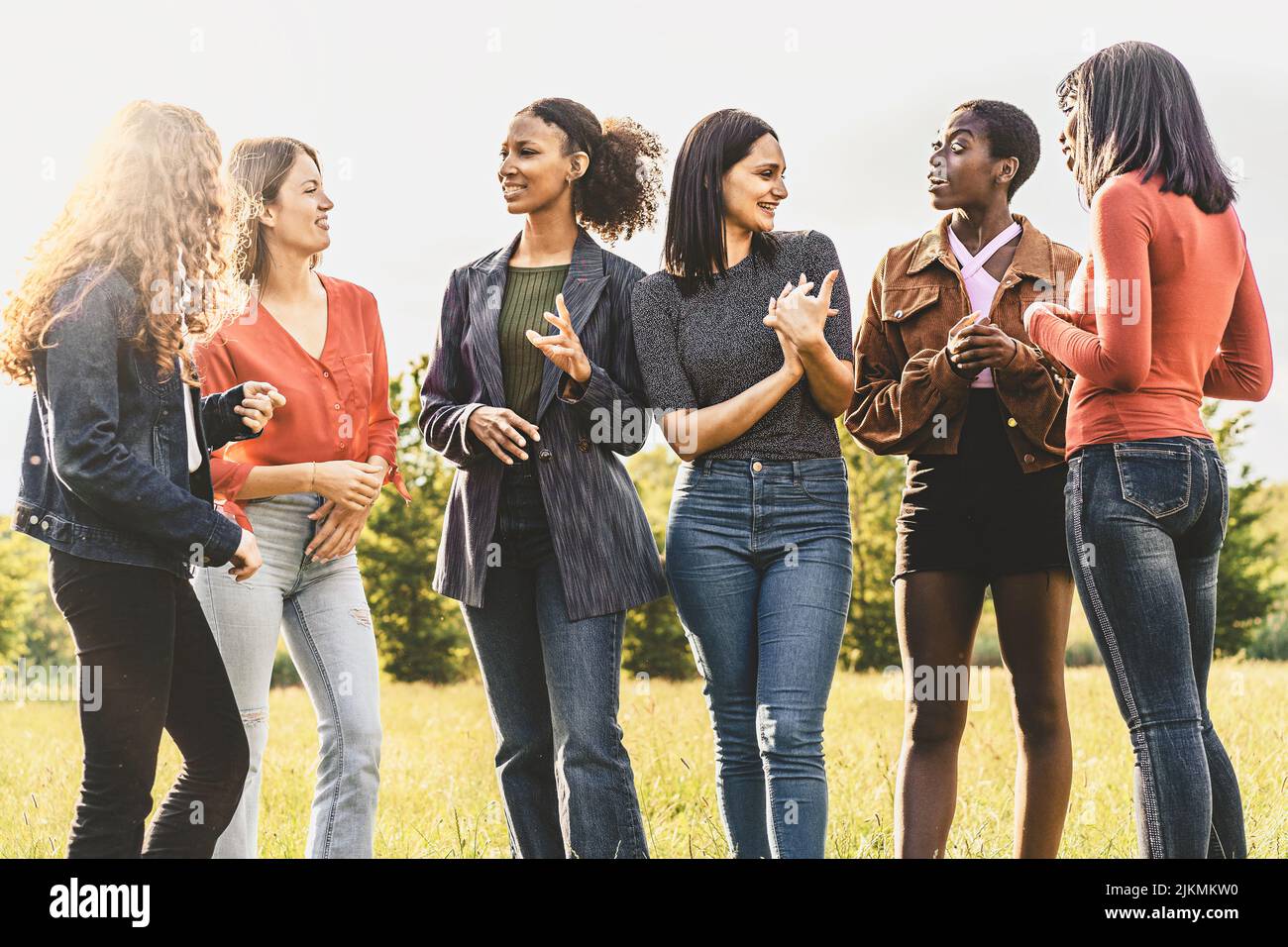 Group of multiethnic girlfriends chatting in the park - millennials girls having fun together - people lifestyle concept Stock Photo
