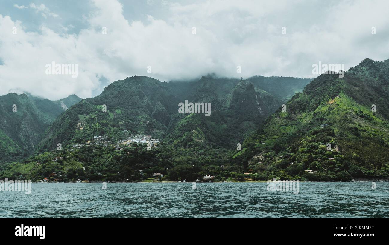 A view of green hills on the coast of Lake Atitlan, Guatemala, Central America on a gloomy day