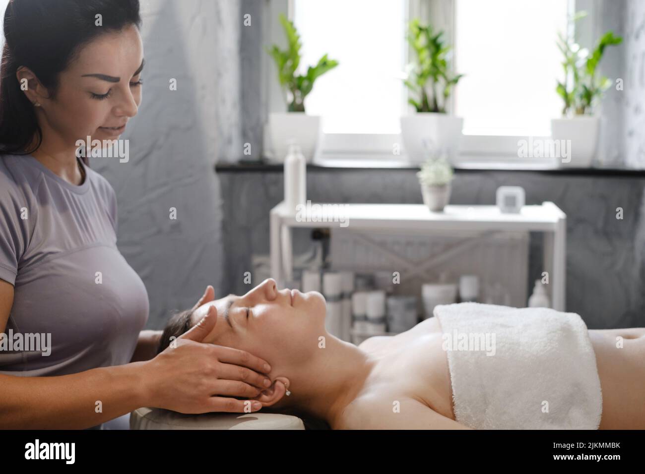 face massage with oil in traditional style made by professional beauty therapist women. anti-age massage Stock Photo