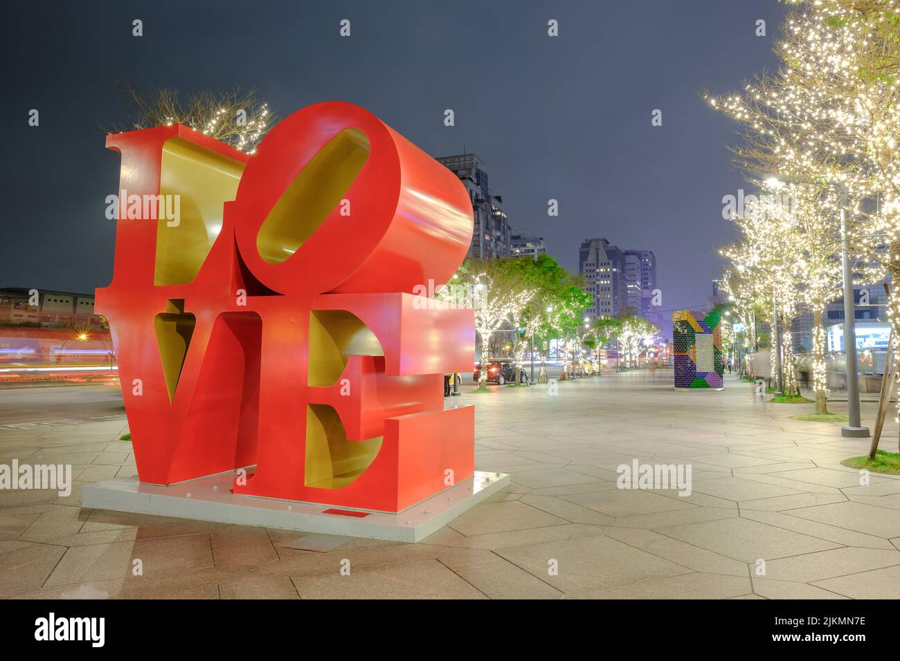 The Love sculpture with illuminated trees in the park at night. New York, USA. Stock Photo