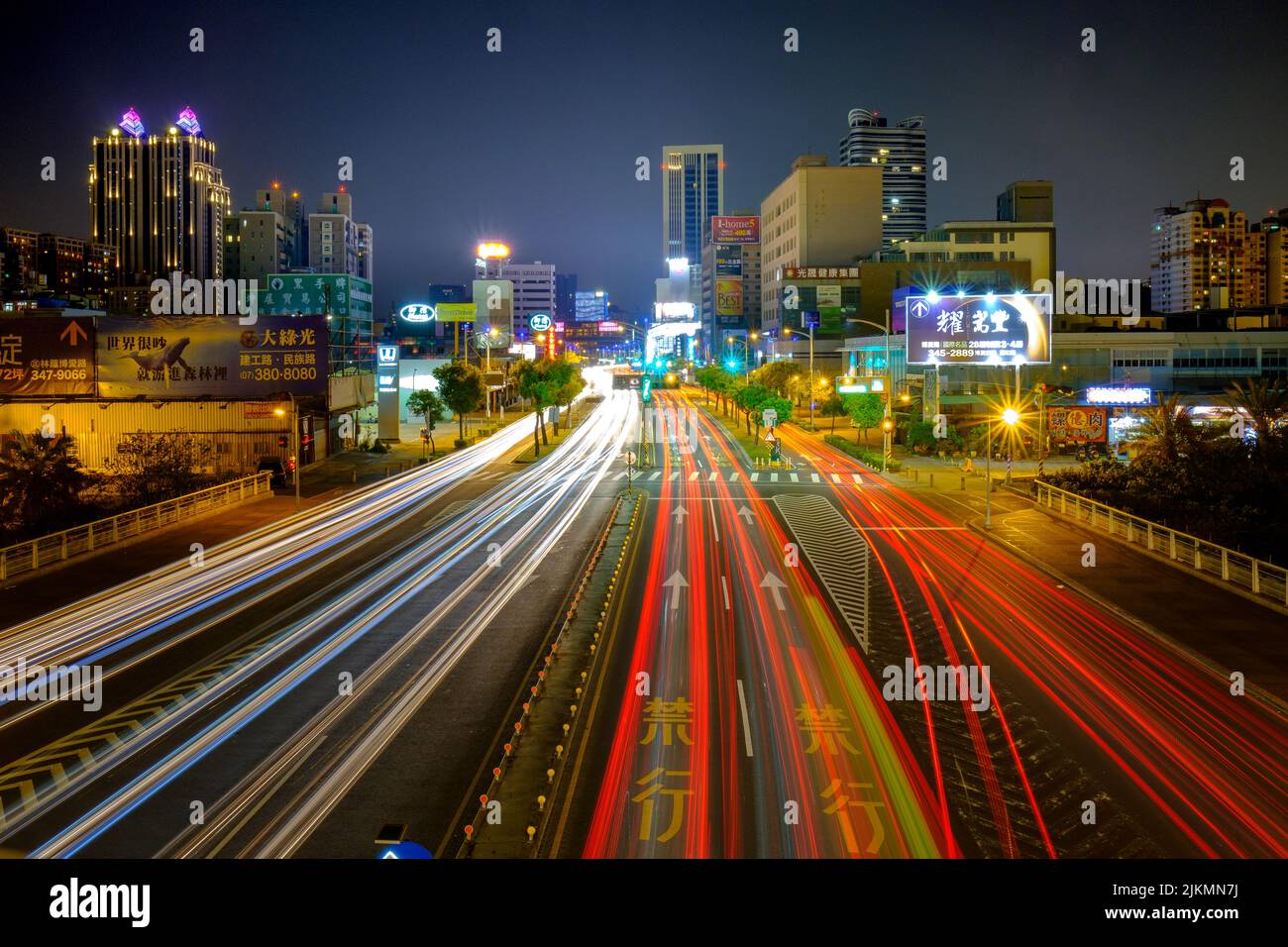 A view of an empty street of an Asian city at night illuminated by neon lights Stock Photo