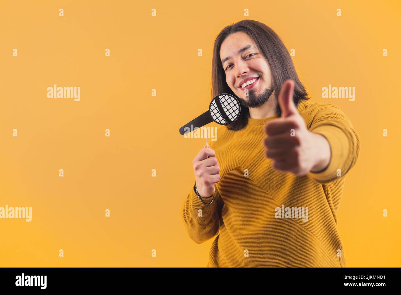 Handsome isolated hispanic bearded man in his 30s hanging a plastic loupe on a stick. High quality photo Stock Photo