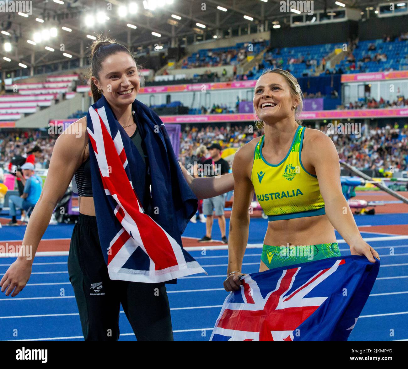 Birmingham, UK. 2nd August 2022; Alexander Stadium, Birmingham, Midlands, England: Day 5 of the 2022 Commonwealth Games: Nina Kennedy (AUS) with her national flag celebrates after winning the Gold Medal in the Pole Vault with a height of 4.60m alongside Imogen Ayris (NZL) who won the Bronze Medal with a height of 4.45m Credit: Action Plus Sports Images/Alamy Live News Stock Photo