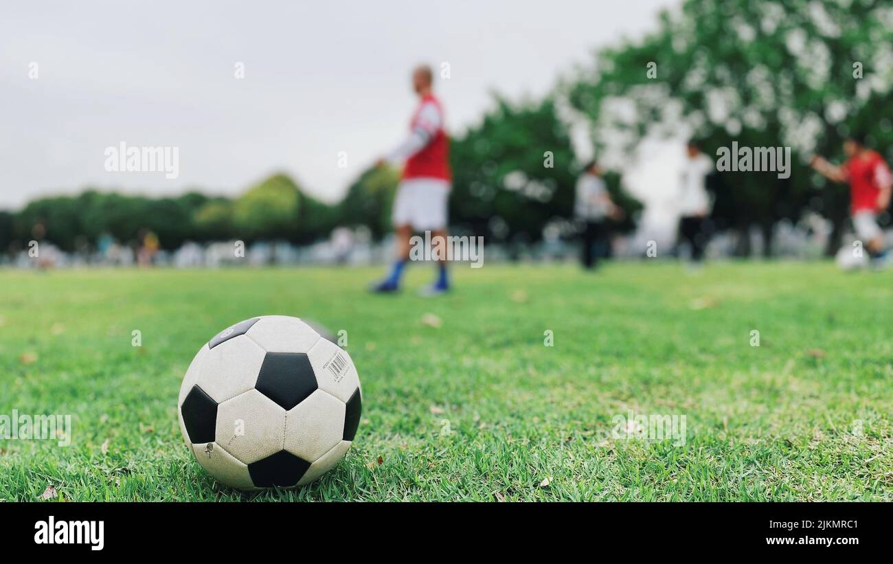 A selective focus shot of a soccer ball in a football field Stock Photo