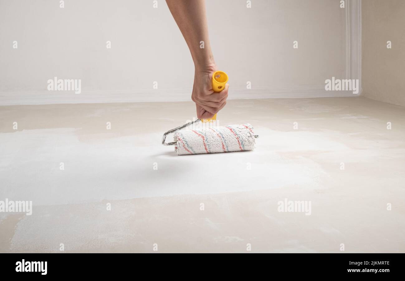 painting the wall with latex paint roller Stock Photo Alamy