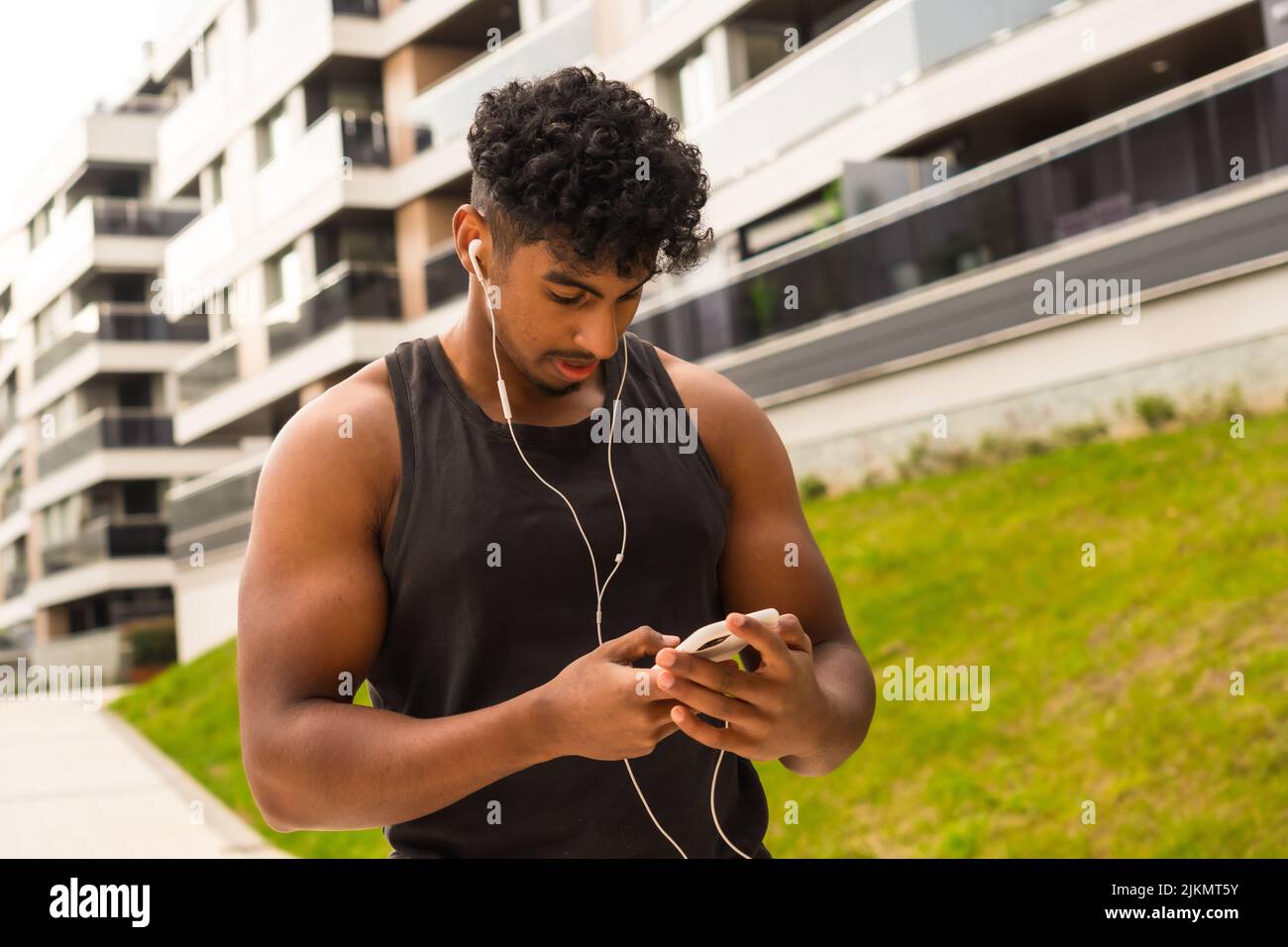 Arab young man doing sports in the city, preparing the music before training Stock Photo