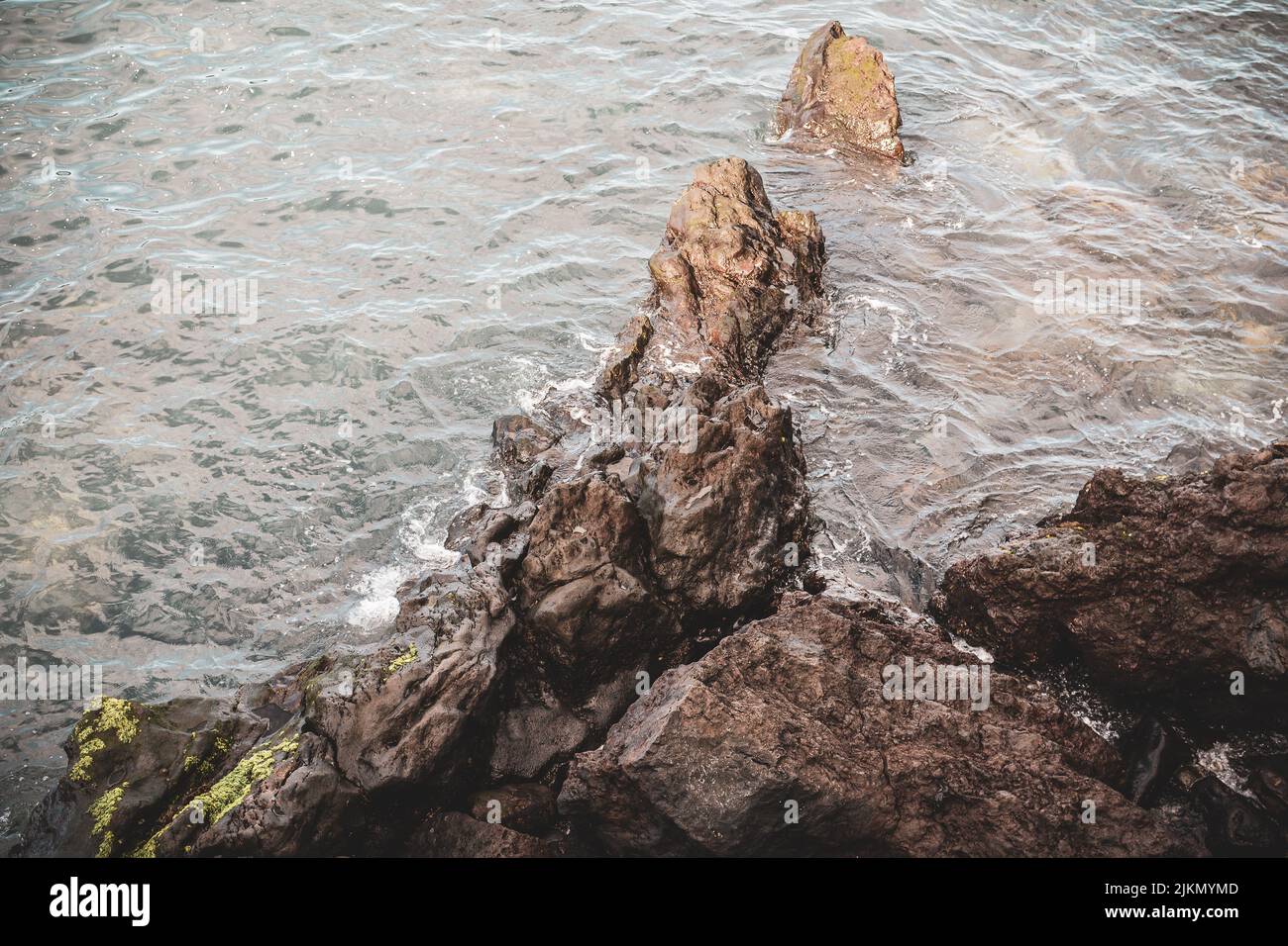 A top view of the ocean hitting the rocky coast Stock Photo - Alamy