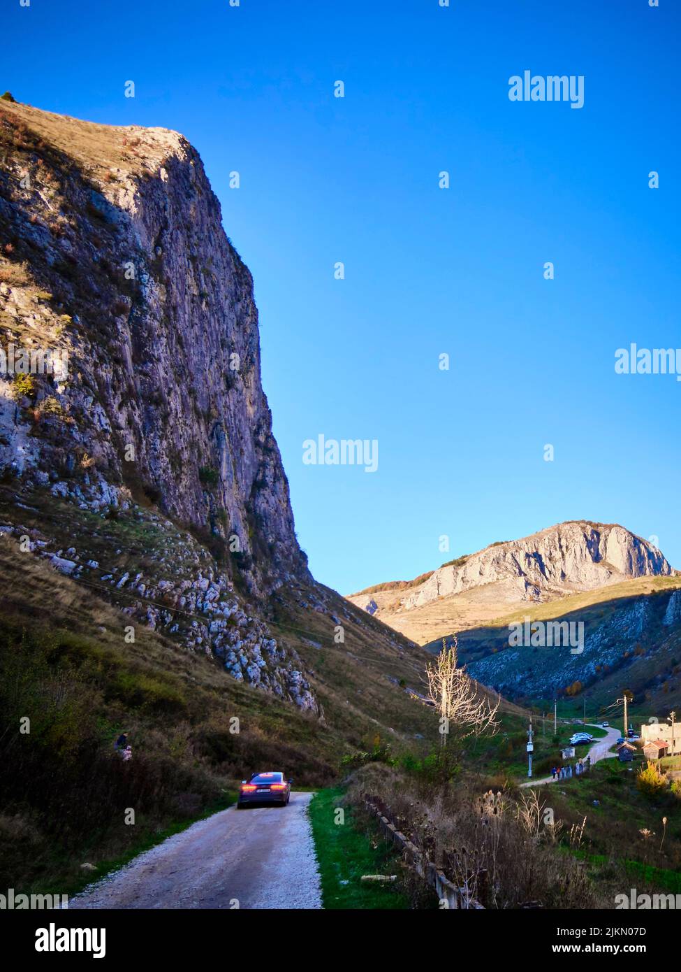 https://c8.alamy.com/comp/2JKN07D/a-vertical-shot-of-a-road-passing-through-carpathian-mountains-against-a-blue-sky-in-romania-2JKN07D.jpg