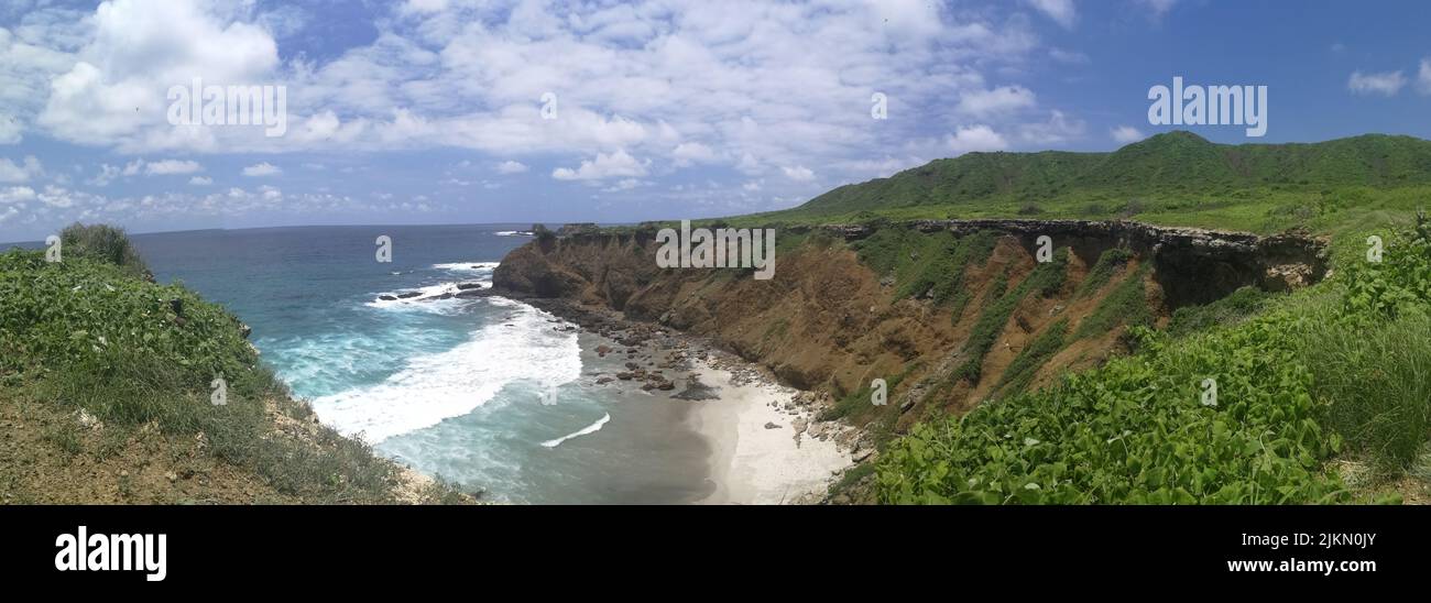 A beautiful view of a sea surrounded by cliffs and greenery Stock Photo ...