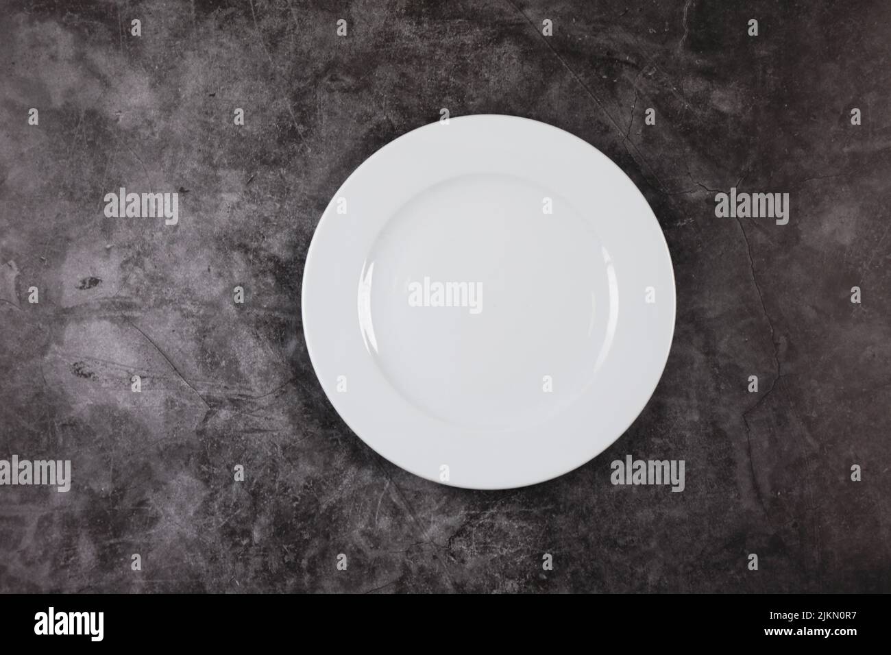 White dinner plate on a grey and white marble surface Stock Photo Alamy