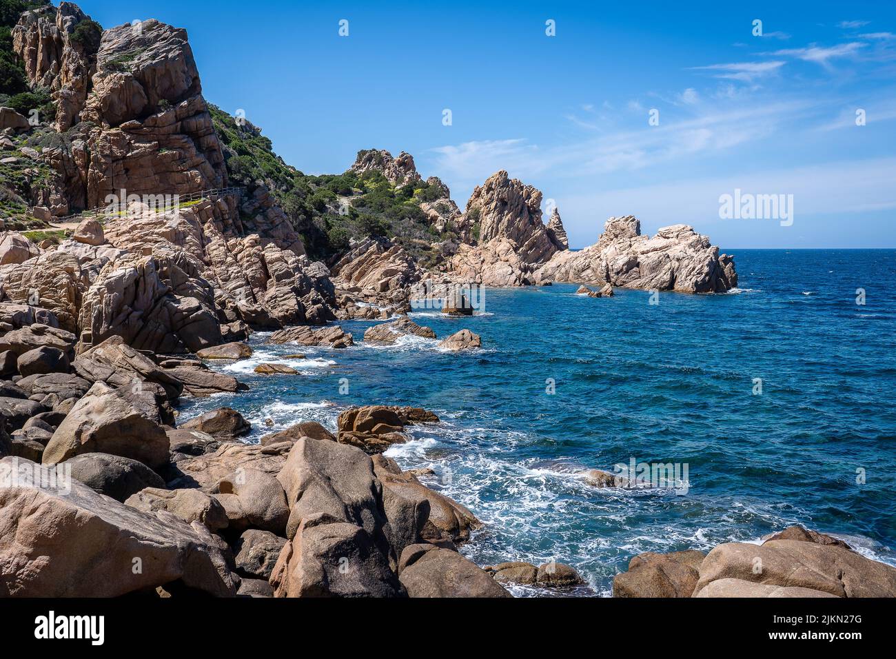 A rocky beach with clear blue water in Sardegna, Italy Stock Photo