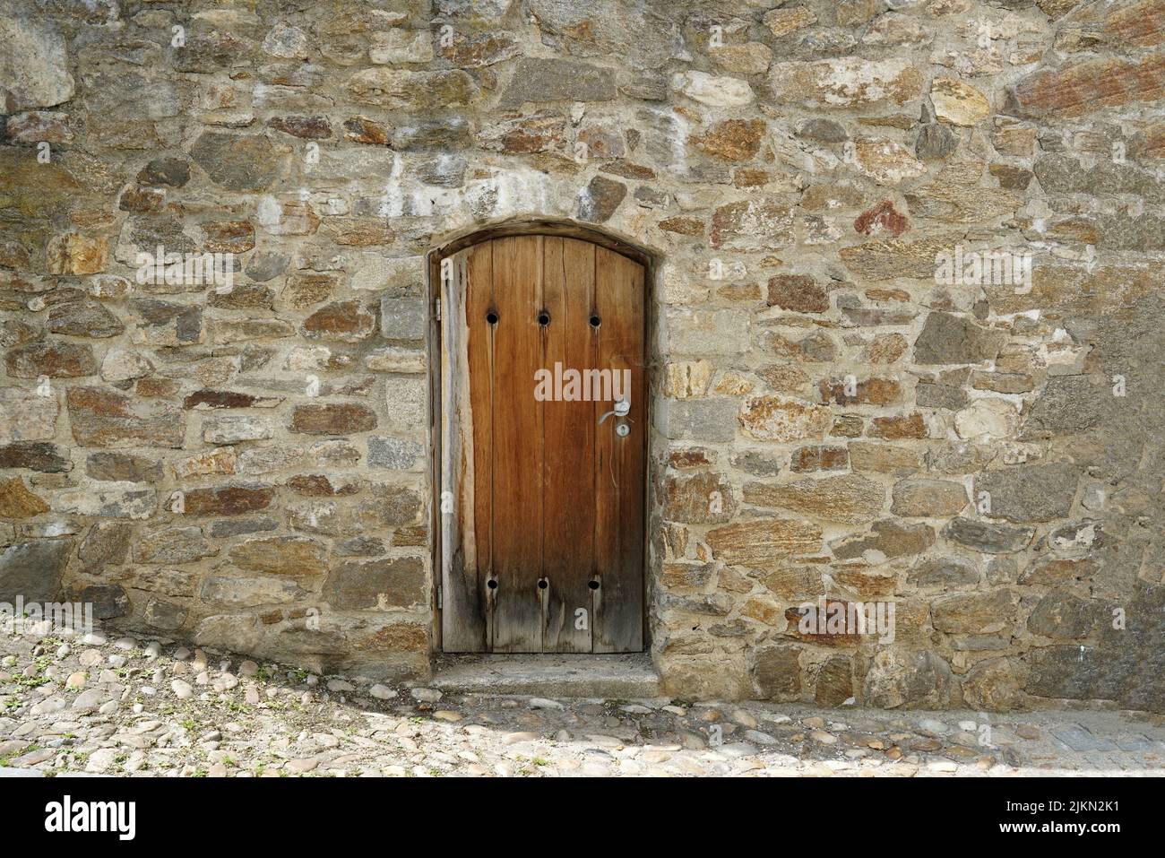 A beautiful view of the wooden door in the old stone wall Stock Photo ...