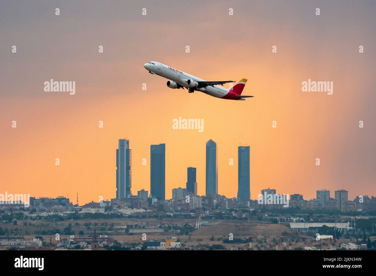 Madrid, Spain. 02nd Aug, 2022. An Iberia airplane departing from Adolfo Suarez Madrid Barajas Airport at sunset during a summer storm, passes by the skyscrapers of the Four Towers Business Area. Rain and hail have reached the city of Madrid during a summer storm, accompanied by high temperatures during a heat wave in which 40 degrees Celsius have been exceeded during the day in some areas of the Community of Madrid. Credit: Marcos del Mazo/Alamy Live News Stock Photo