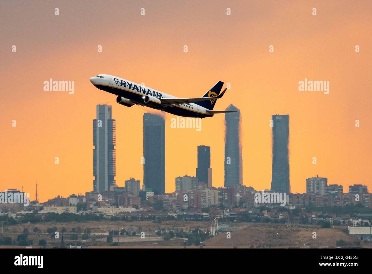 Madrid, Spain. 02nd Aug, 2022. A Ryanair airplane departing from Adolfo Suarez Madrid Barajas Airport at sunset during a summer storm, passes by the skyscrapers of the Four Towers Business Area. Rain and hail have reached the city of Madrid during a summer storm, accompanied by high temperatures during a heat wave in which 40 degrees Celsius have been exceeded during the day in some areas of the Community of Madrid. Credit: Marcos del Mazo/Alamy Live News Stock Photo