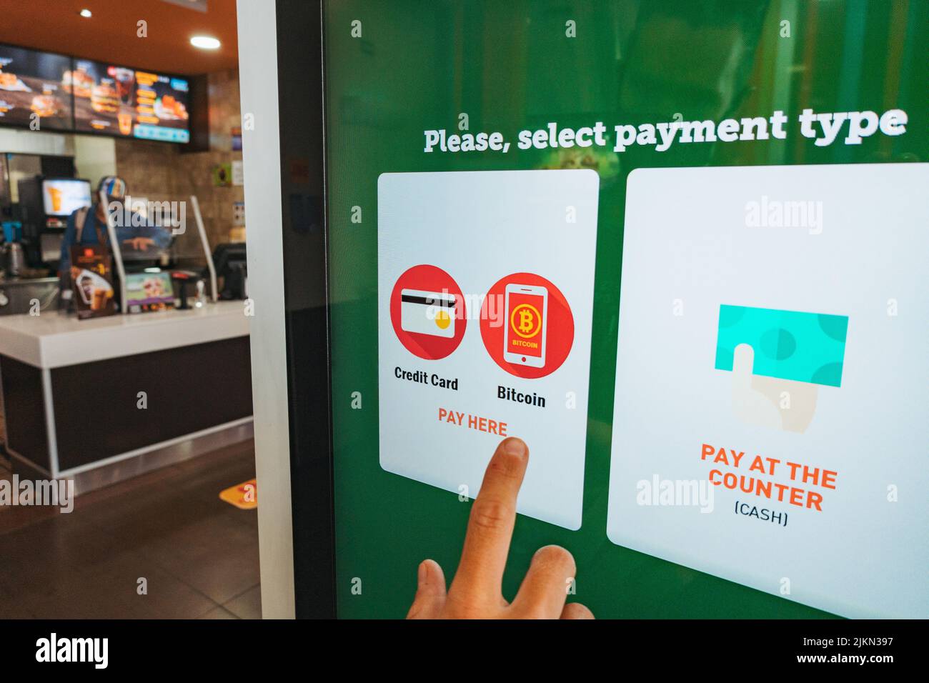A person pays for their food with Bitcoin over the Lightning Network on a McDonald's ordering kiosk in El Salvador Stock Photo