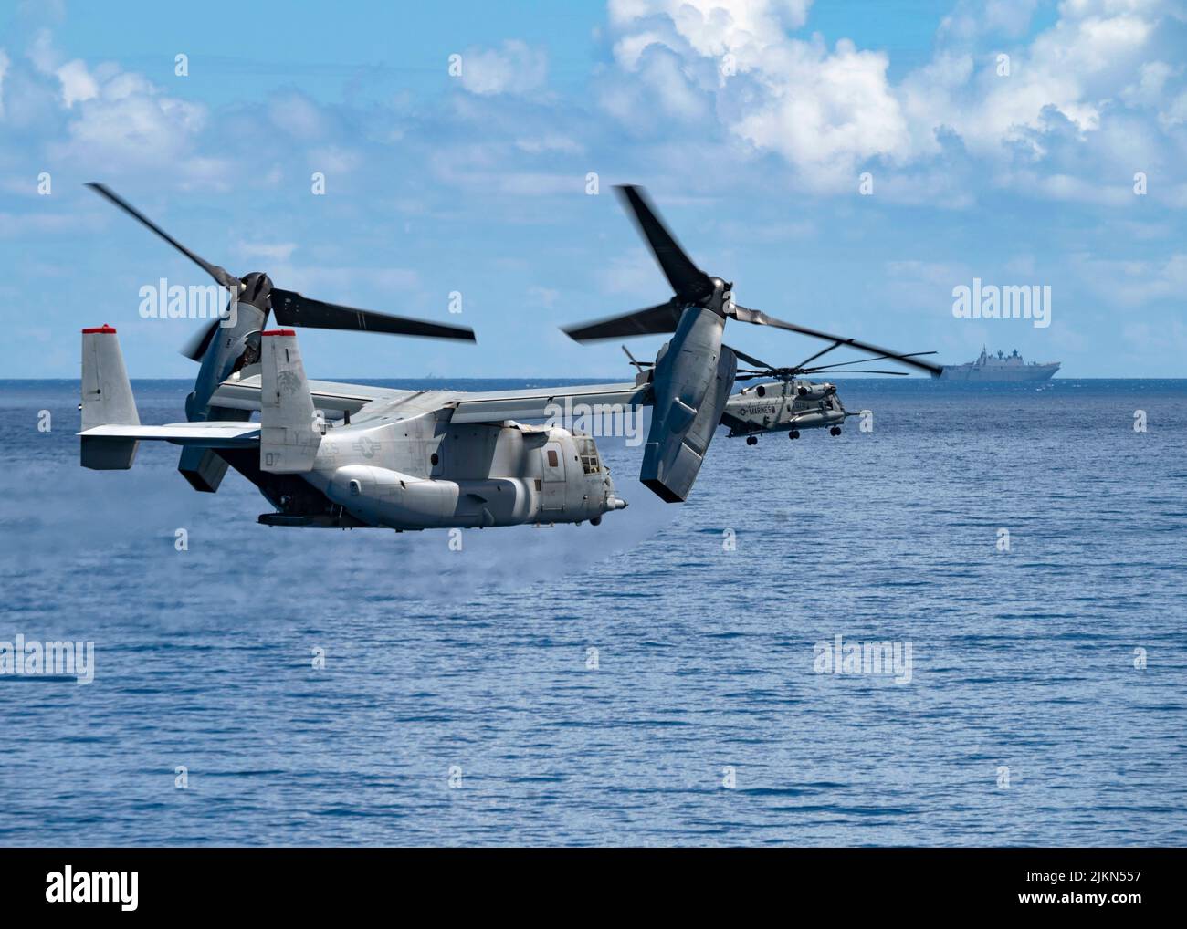 PACIFIC OCEAN (July 29, 2022) A U.S. Marine Corps MV-22B Osprey, attached to Marine Medium Tiltrotor Squadron (VMM) 363, left, and a U.S. Marine Corps UH-1Y Huey, attached to Marine Light Attack Helicopter Squadron (HMLA) 169, conducts flight operations with Royal Australian Navy Canberra-class landing helicopter dock HMAS Canberra (L02) during an amphibious raid as part of Rim of the Pacific (RIMPAC) 2022, July 29. Twenty-six nations, 38 ships, three submarines, more than 170 aircraft and 25,000 personnel are participating in RIMPAC from June 29 to Aug. 4 in and around the Hawaiian Islands an Stock Photo