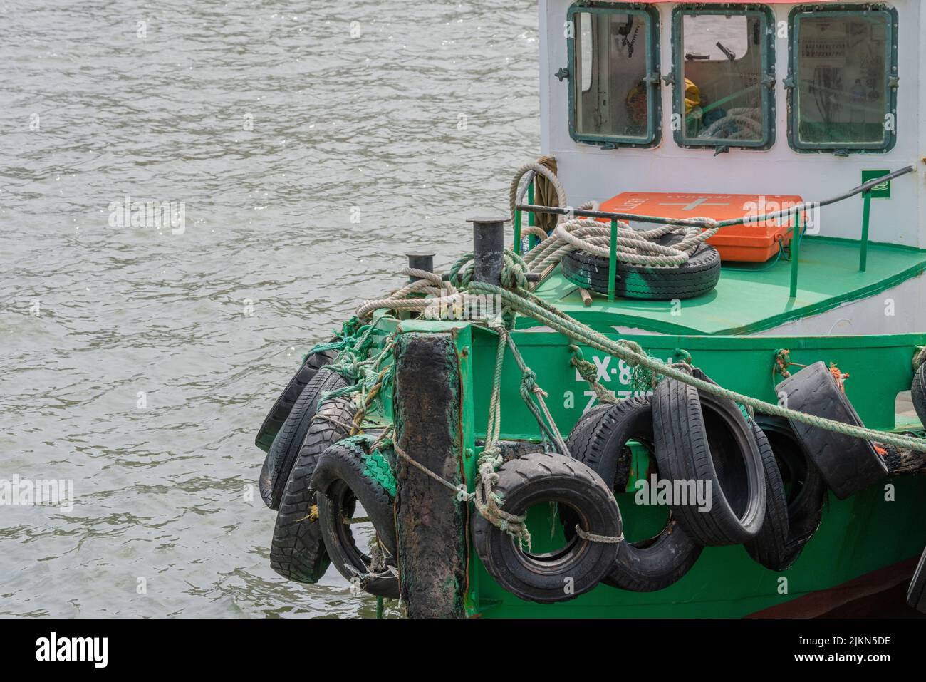 A beautiful shot of a green tugboat in water, designed to push pull and tow barges or ships Stock Photo