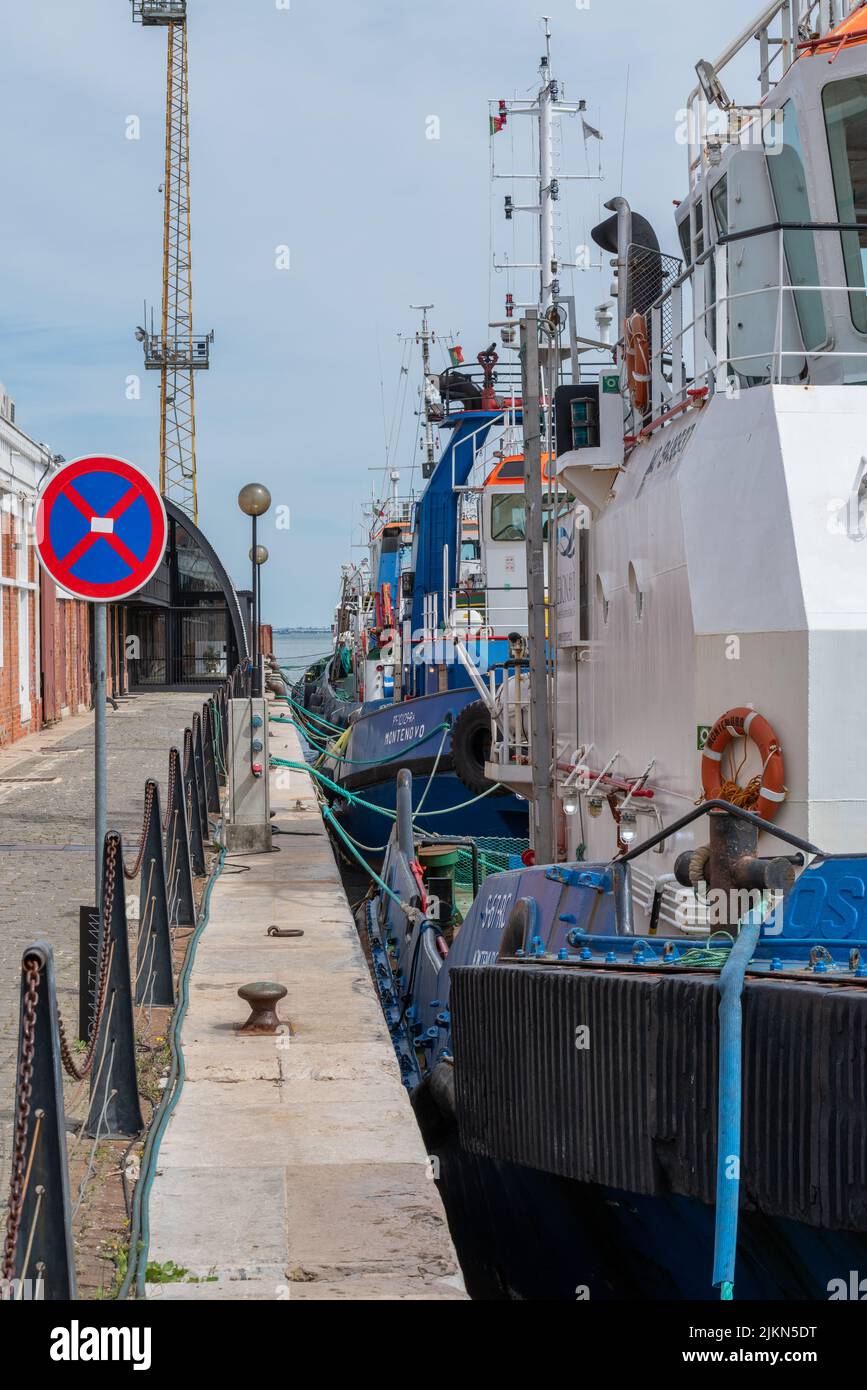A vertical shot of tugs in the dock, the boats designed to push pull