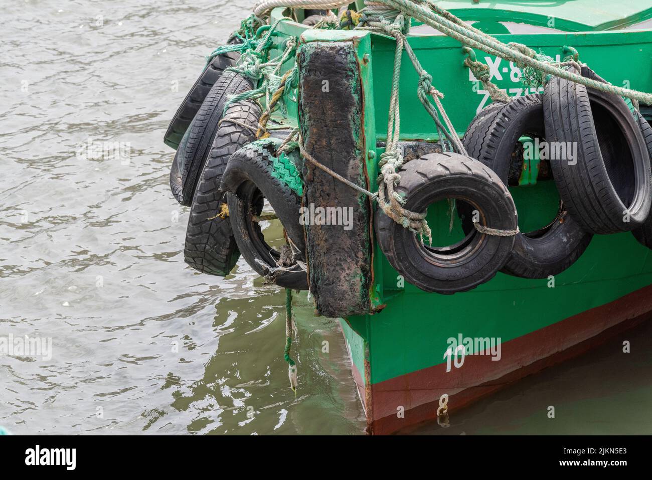 A closeup shot of a green tugboat in water, designed to push pull and tow barges or ships Stock Photo