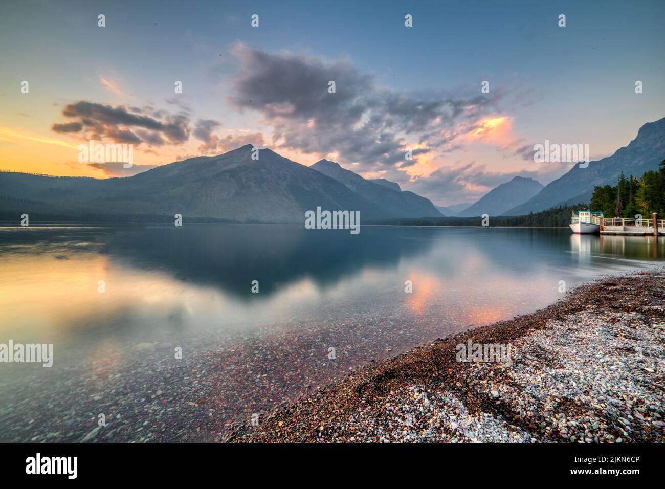 A breathtaking view of Lake McDonald with a dock at sunset in Glacier