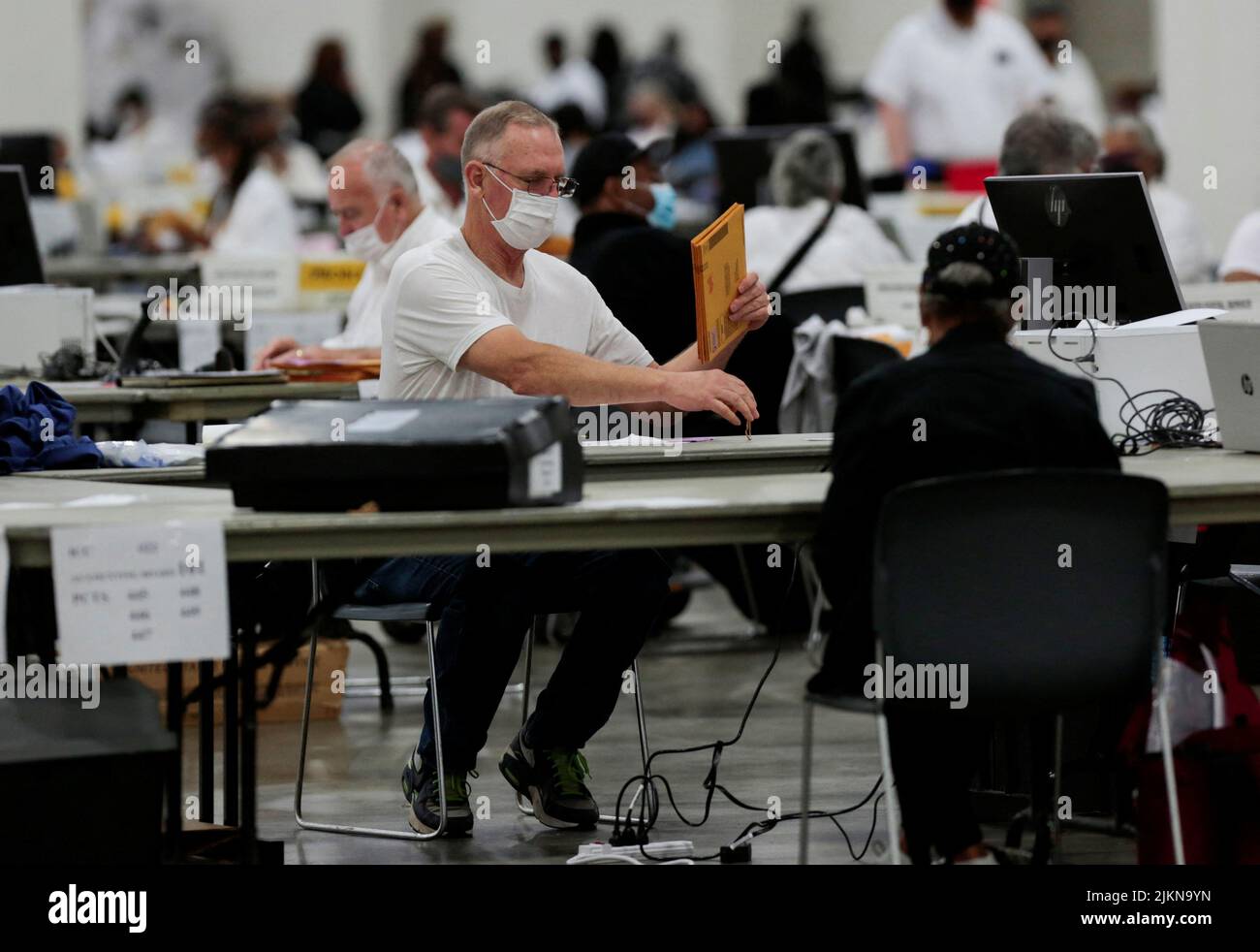 An election worker prepares absentee ballots for counting at Huntington Place during the primary election in Detroit, Michigan, U.S. August 2, 2022.  REUTERS/Rebecca Cook Stock Photo