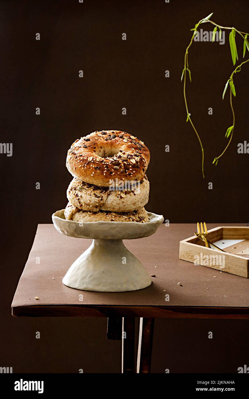 A closeup shot of fresh bread bagel rolls with seeds on a table Stock Photo