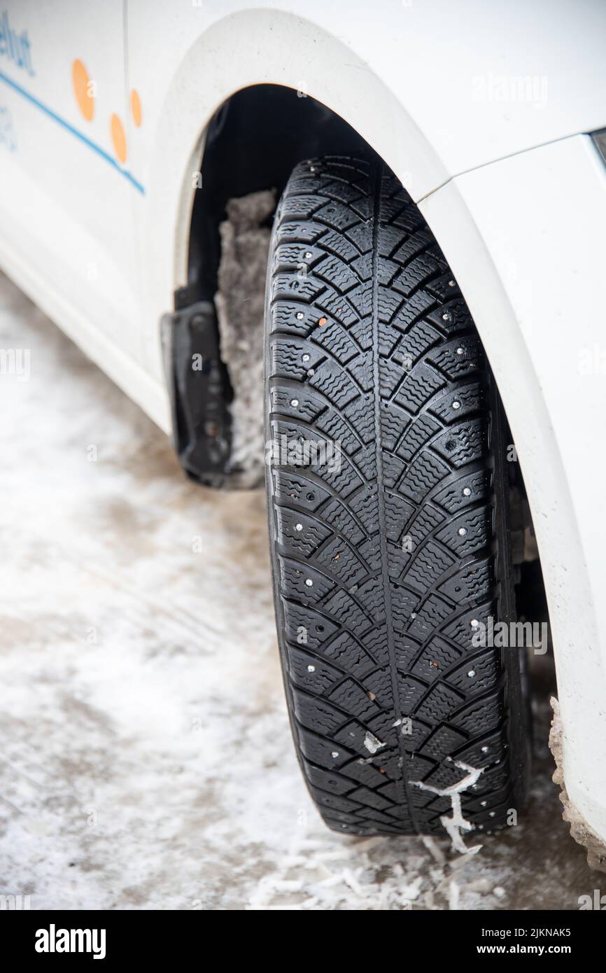 A vertical closeup shot of winter tire of a white car Stock Photo