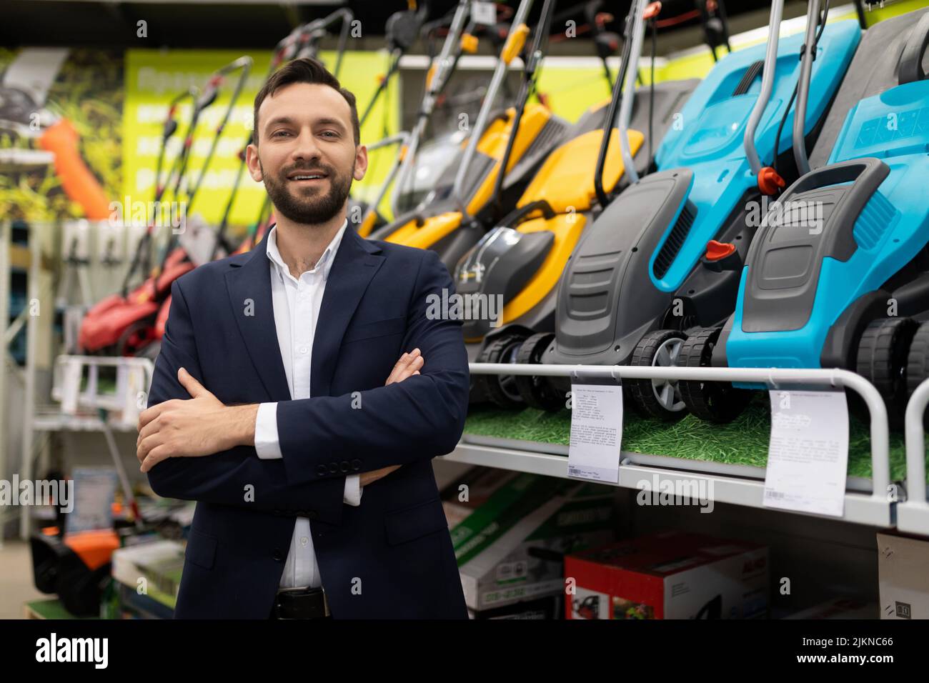 portrait of a shop manager selling electric and petrol lawn mowers Stock Photo