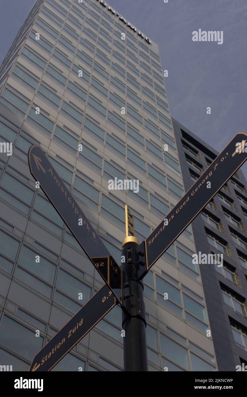 A low angle shot of street signs against high rise modern building on a sunny day at Amsterdam Zuid, The Netherlands Stock Photo