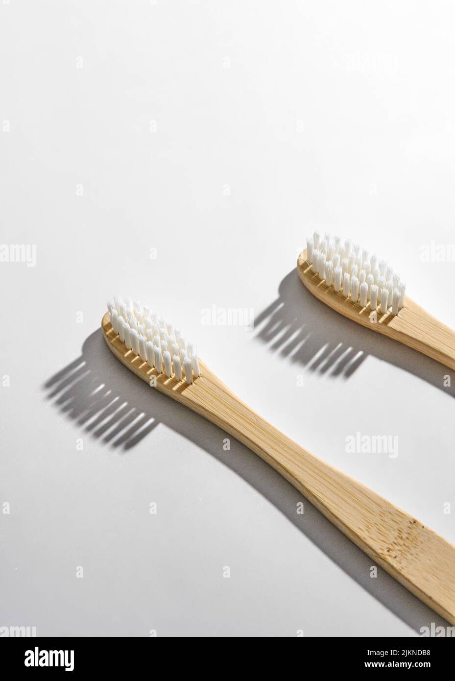 A photo of eco-friendly bamboo toothbrushes with white bristles on a ...