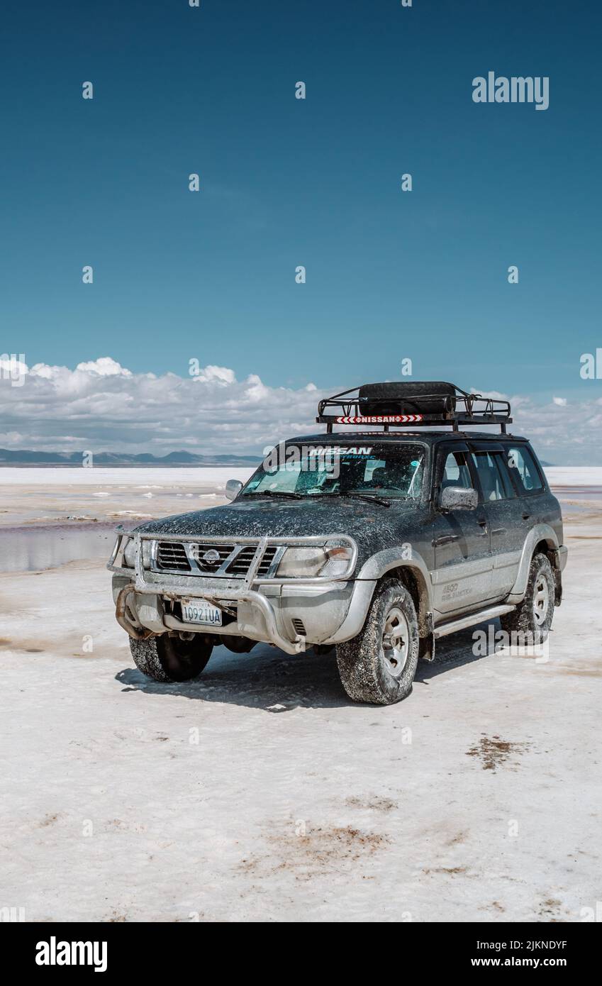 A scenic shot of a Nissan SUV in the Uyuni salt flats, Bolivia Stock Photo