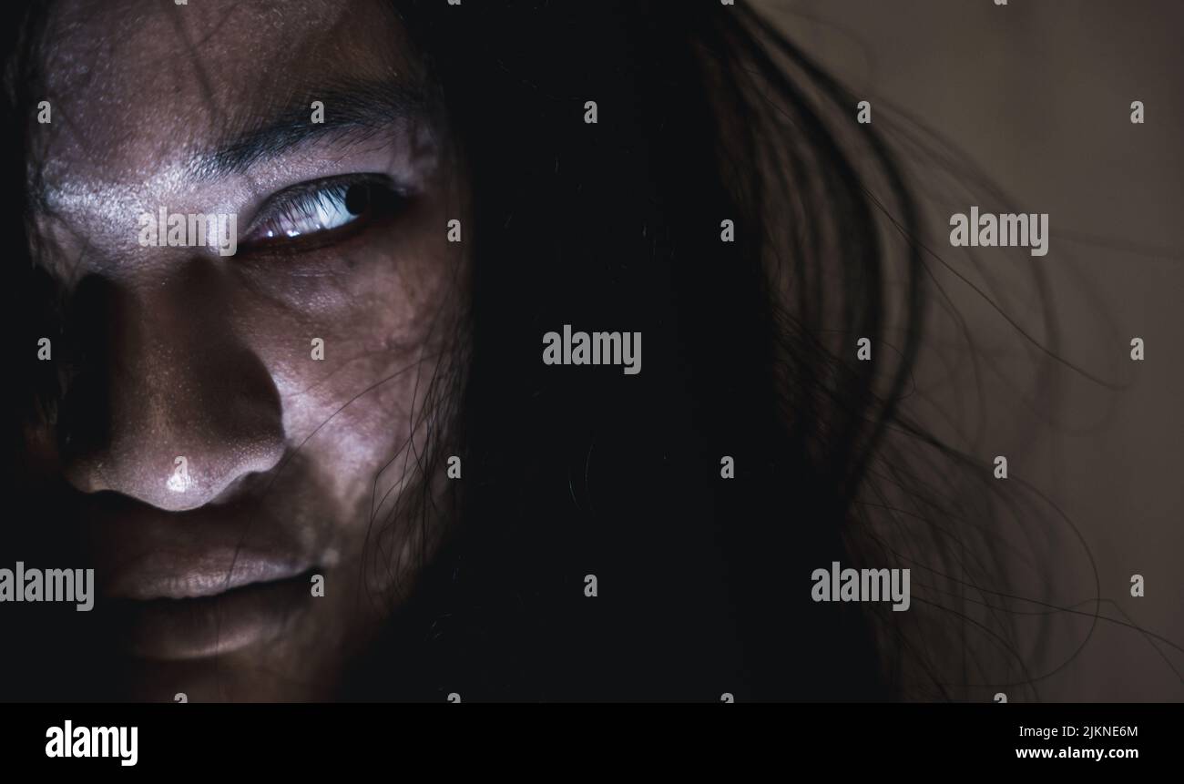 Scary ghost woman. Close up face of Asian woman ghost or zombie horror creepy scary have hair covering the face her eye at abandoned house dark tone, Stock Photo