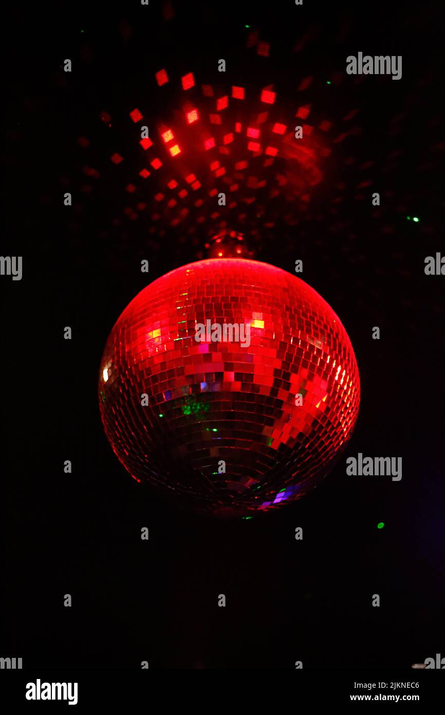 A beautiful shot of a red shining disco ball glowing in the dark in a nightclub in Jakarta, Indonesia Stock Photo