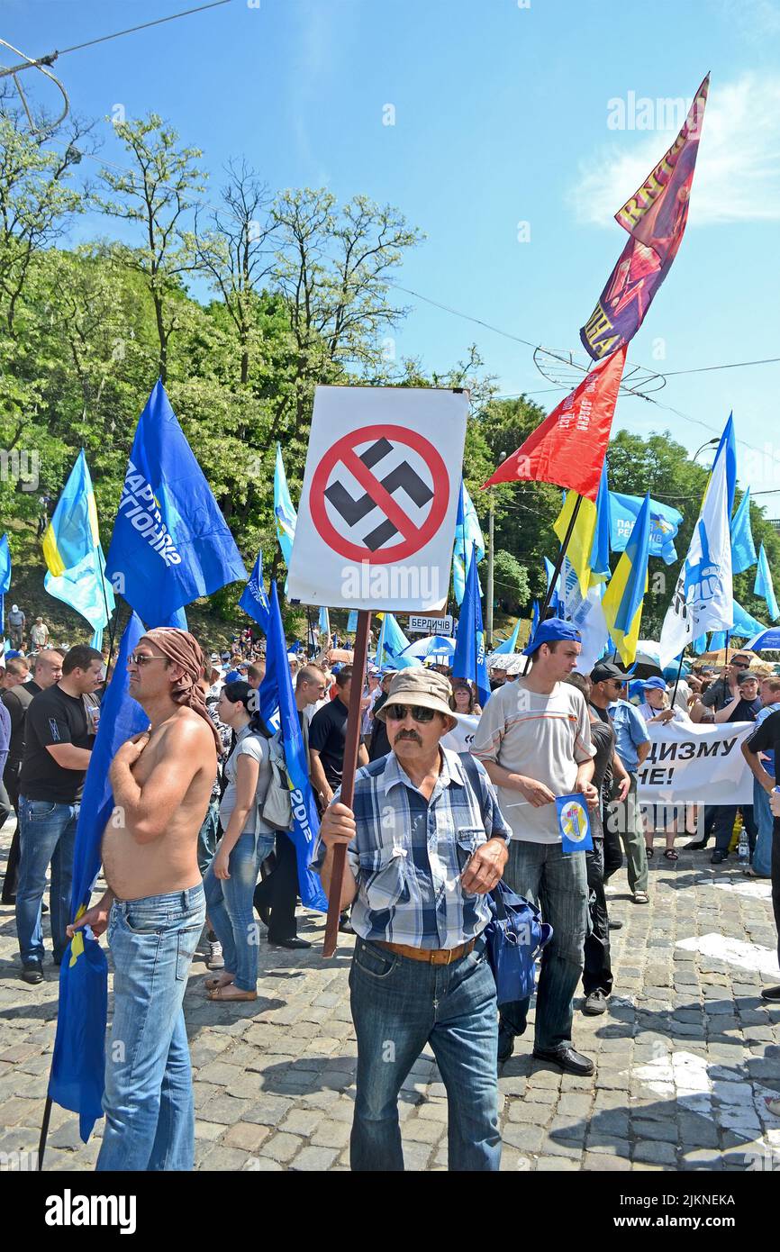 KIEV - MAY 18: Political meeting against fascism on May 18, 2013 in Kiev, Ukraine. Representative of Party of Regions carry the anti-fascism sign. Stock Photo
